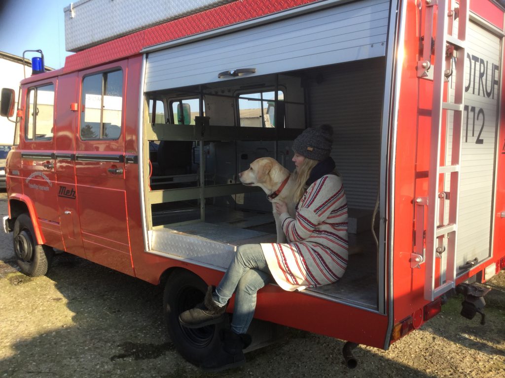 Frau mit Hund in Feuerwehrauto sitzend