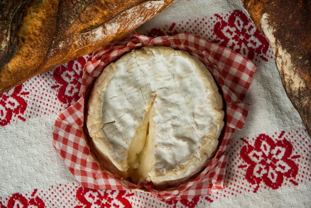 Camembert und Baguette auf einem rot-weiß kariertem Tischtuch